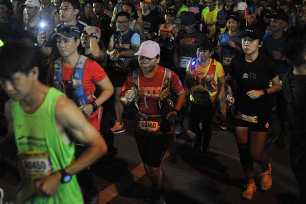 Close-up of a runner with sweat on their brow and determination in their eyes.
