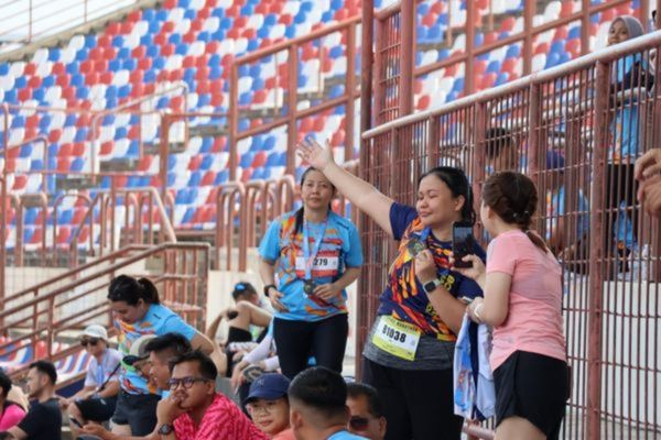 A runner happily celebrating her victory with a medal.