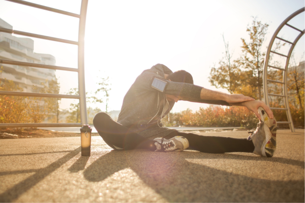 A runner stretching on a beautiful sunny day.