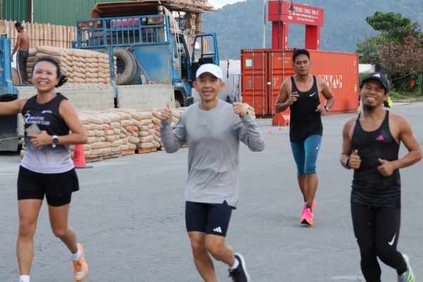 Runners happily running across the marathon path.
